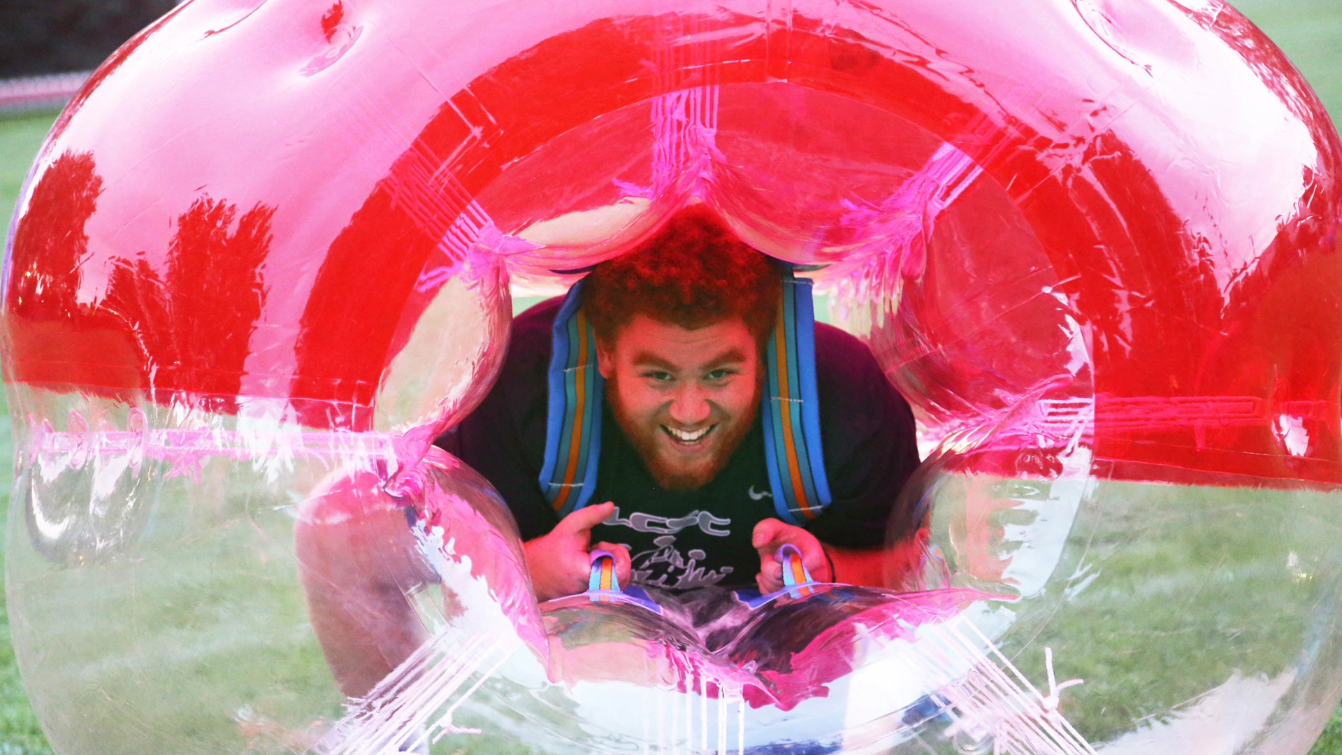 Male student inside a bubble ball smiling